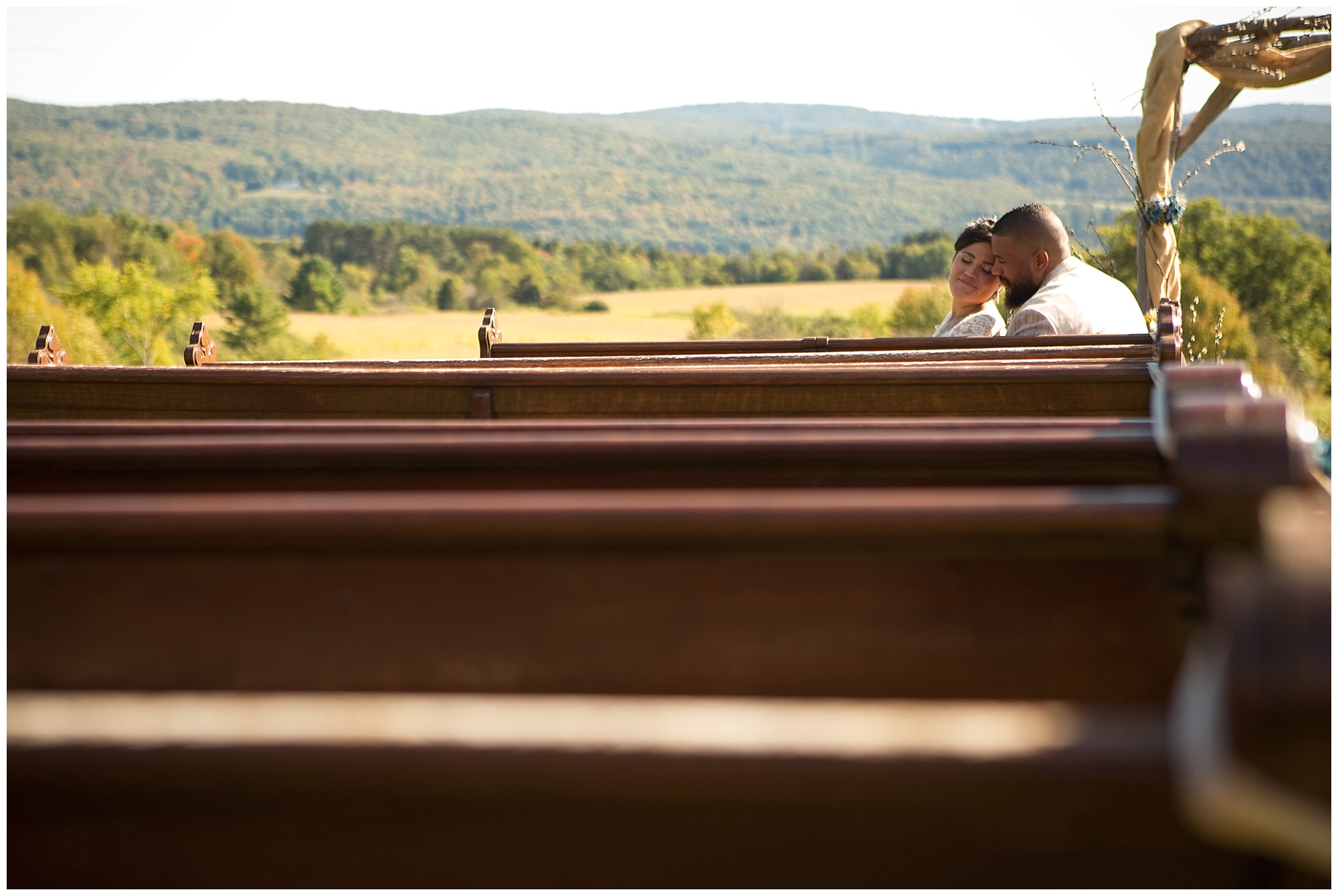 Bride and groom sharing a moment in these outdoor pew shortly before ceremony time.