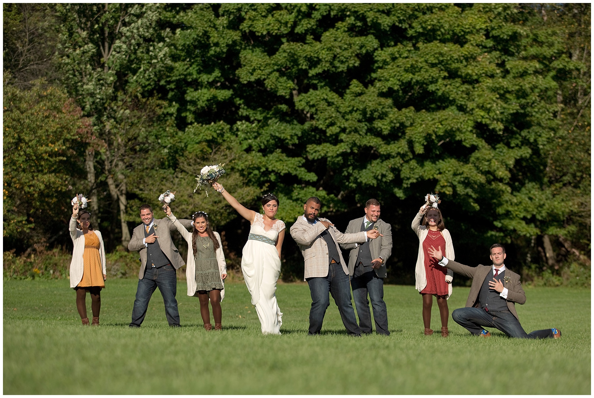 Wedding party photo with hands in the air and playing to the camera
