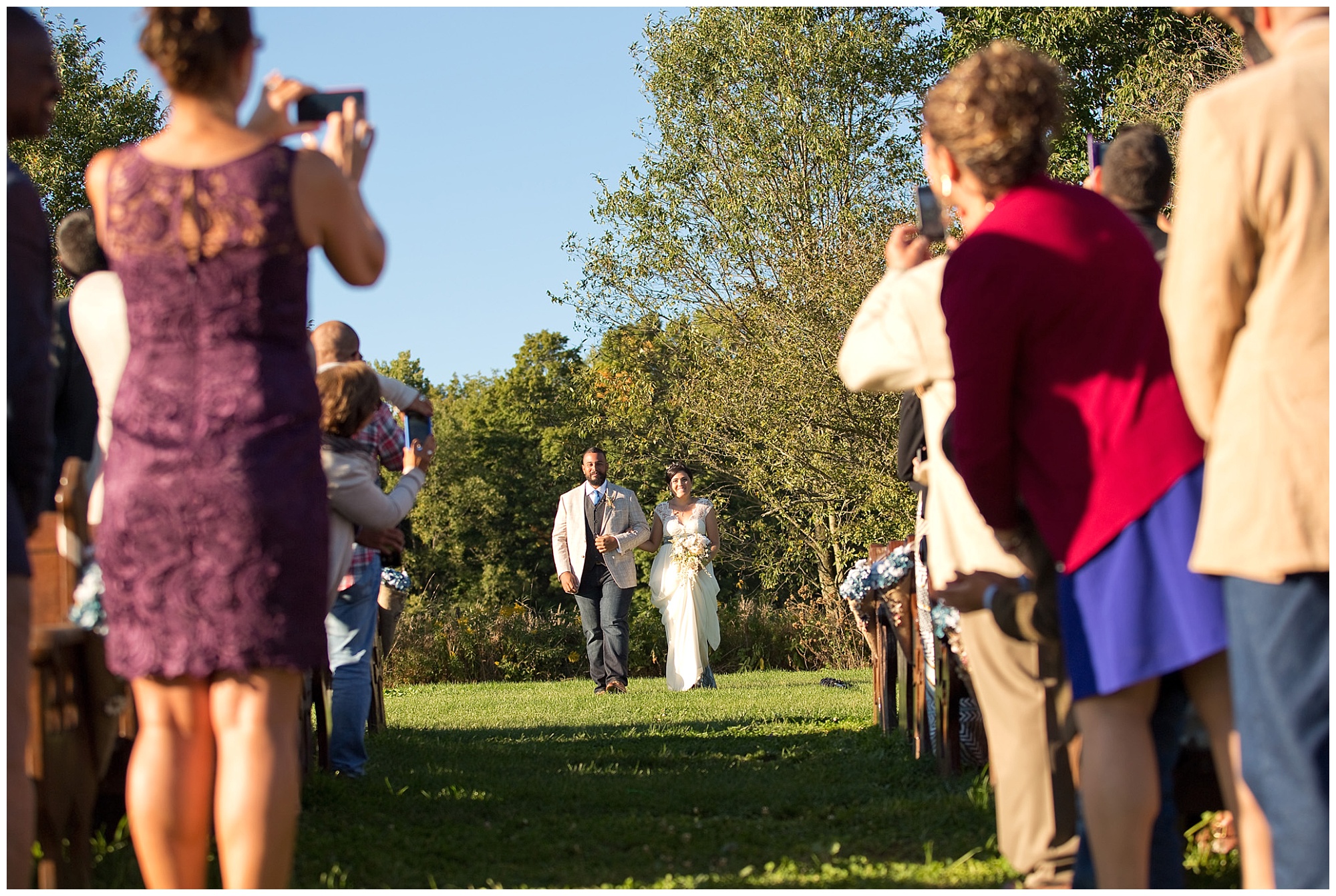 Bride and groom walking together at the processional of their wedding ceremony.