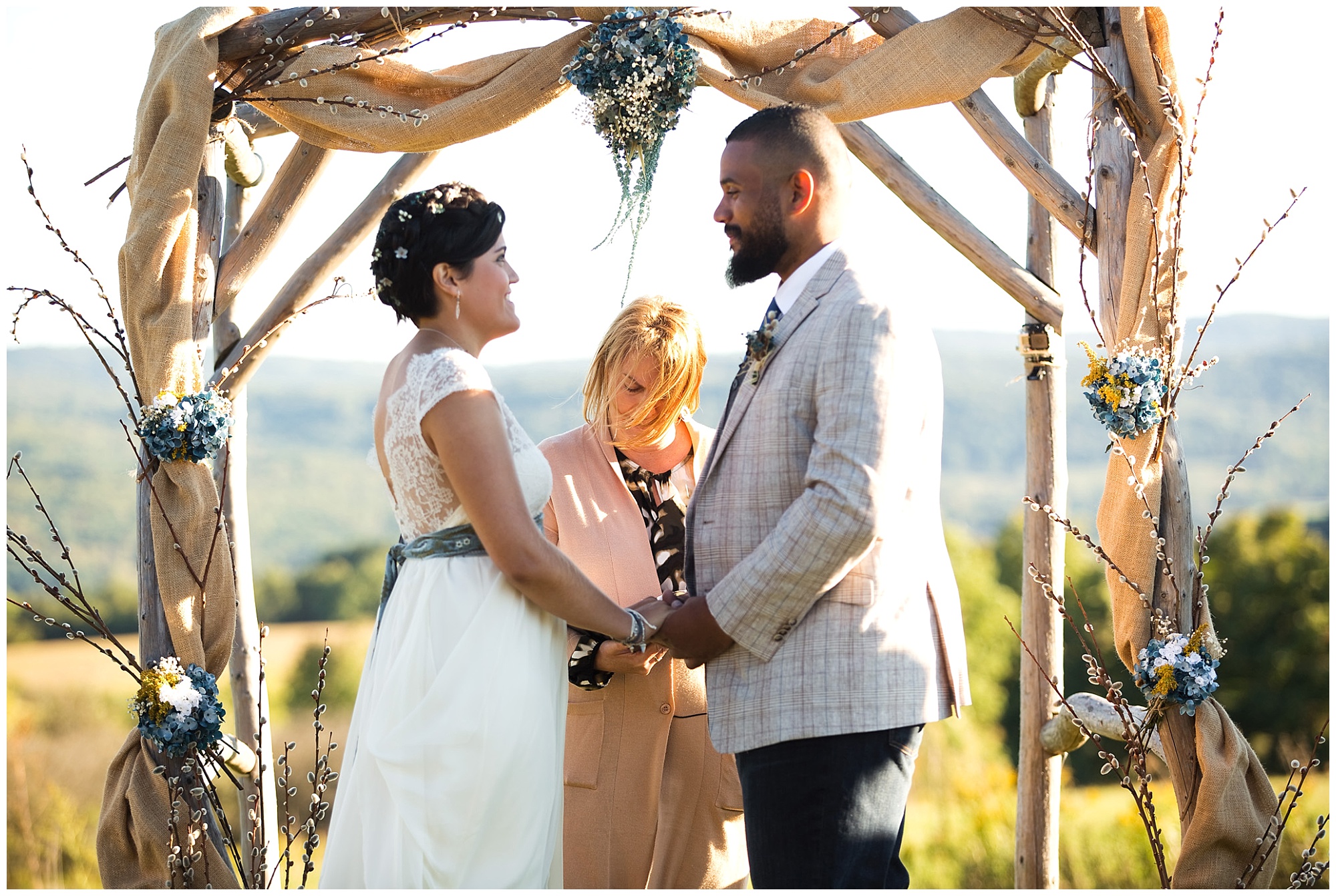 bride and grrom at an outdoor ceremony facing eachother hand in hand.