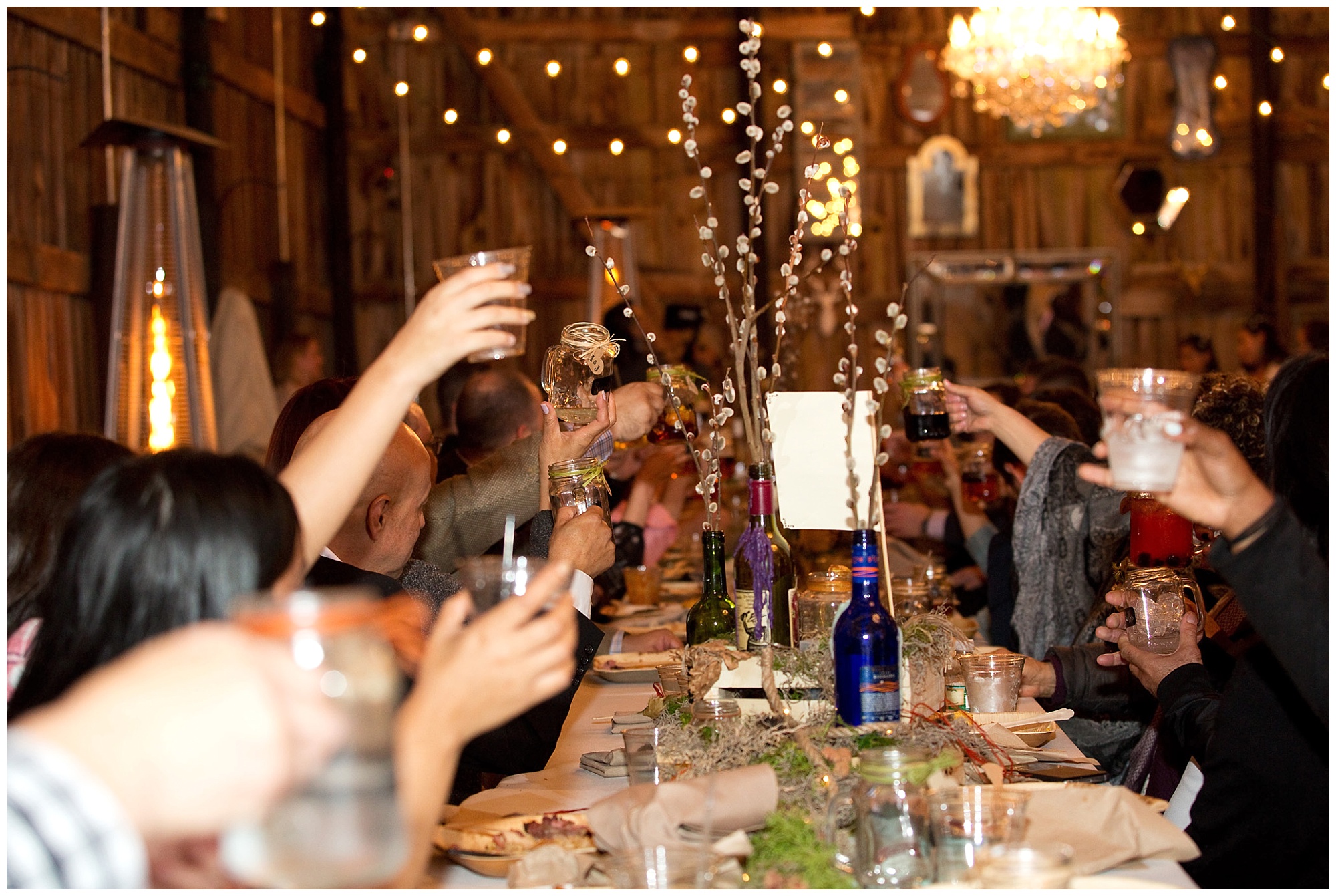 Weeding guests raising glasses to the brid and groon in this photo