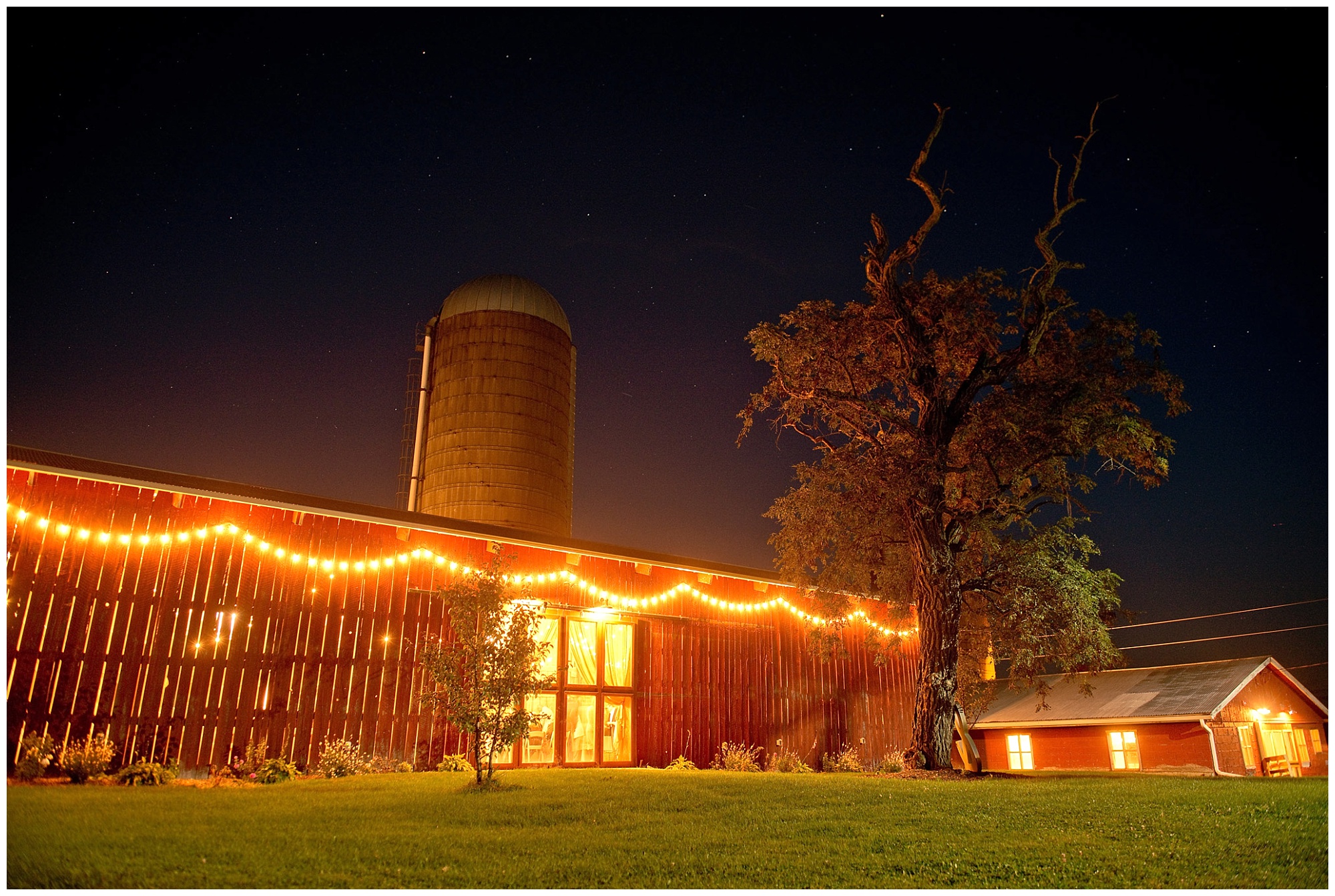 Photo of barn reception from exterior at nighttime lighted up beautifully.