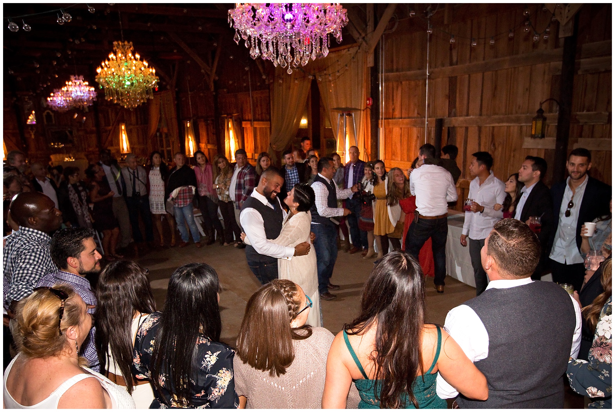 Photo of bride and groom encircled by their family and friends for a last dance of the evening.