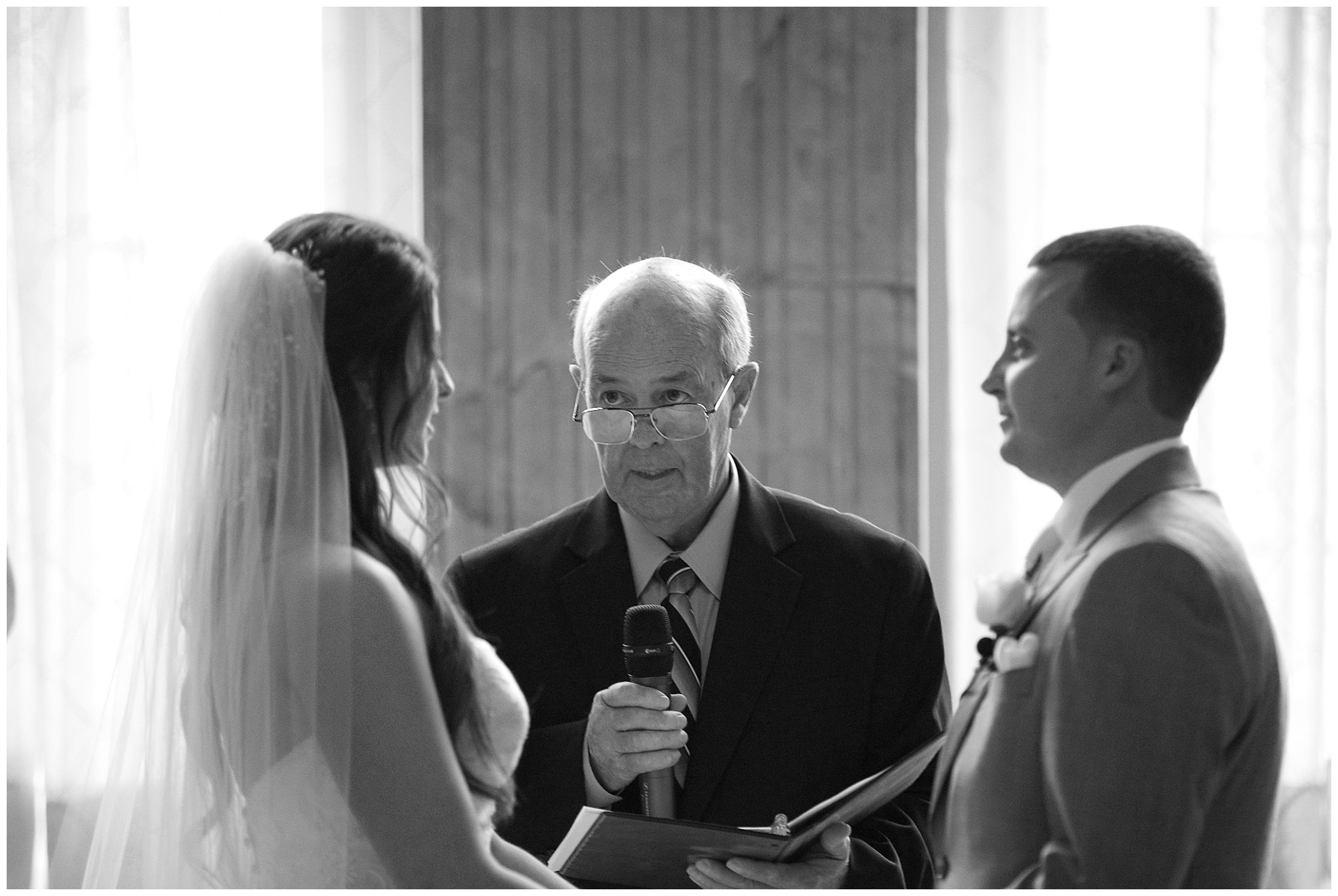 A photo a bride, groom and their wedding officiant during the ceremony..