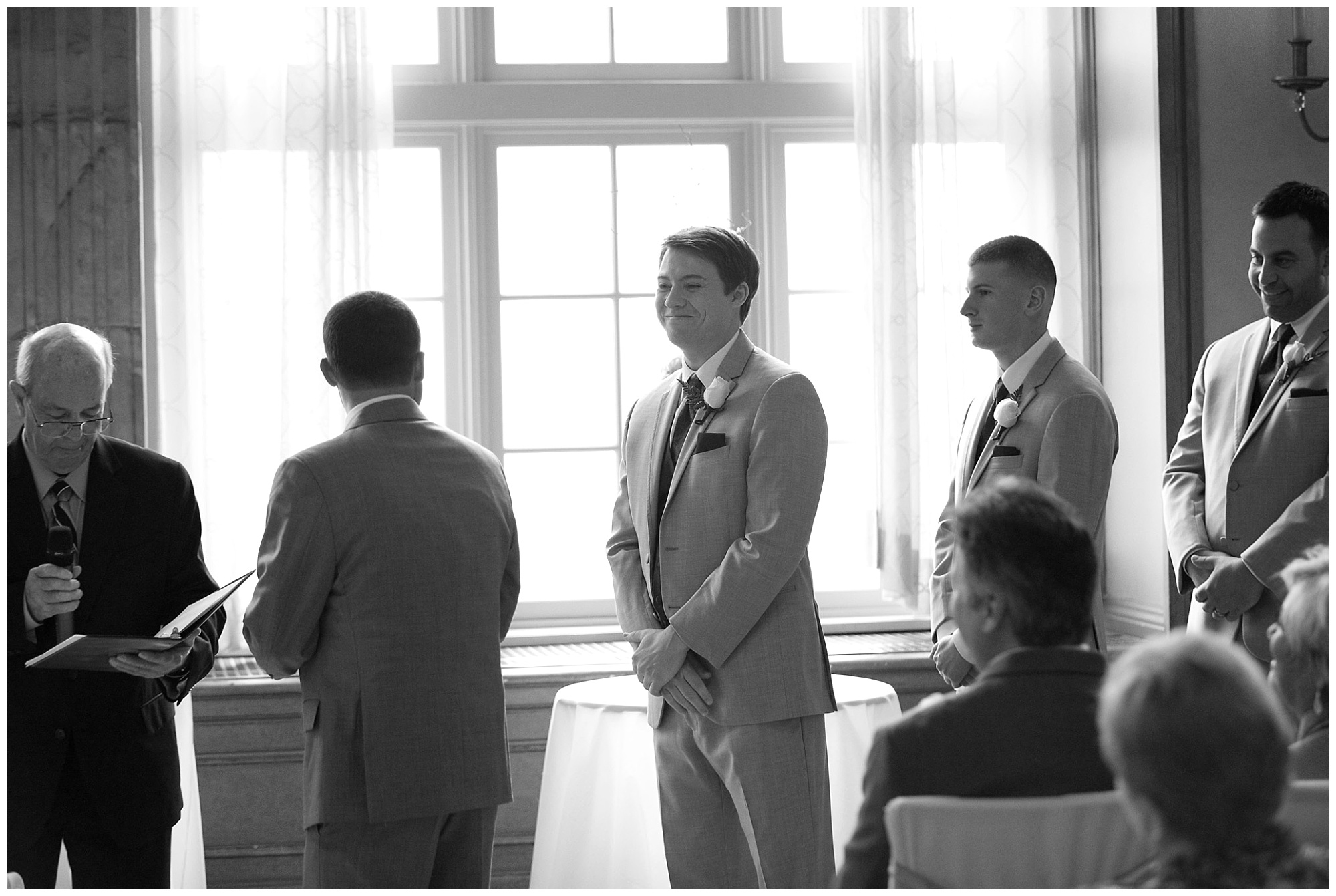 Photo of a best man smiling at the groom.