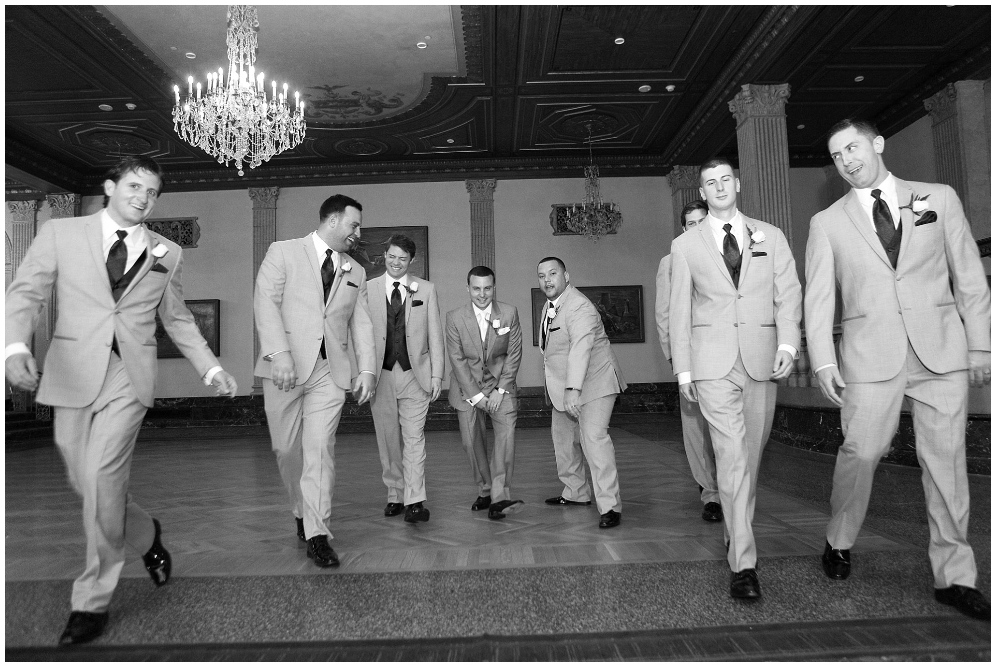 Photo of a groom and his groomsmen walking toward the camera.