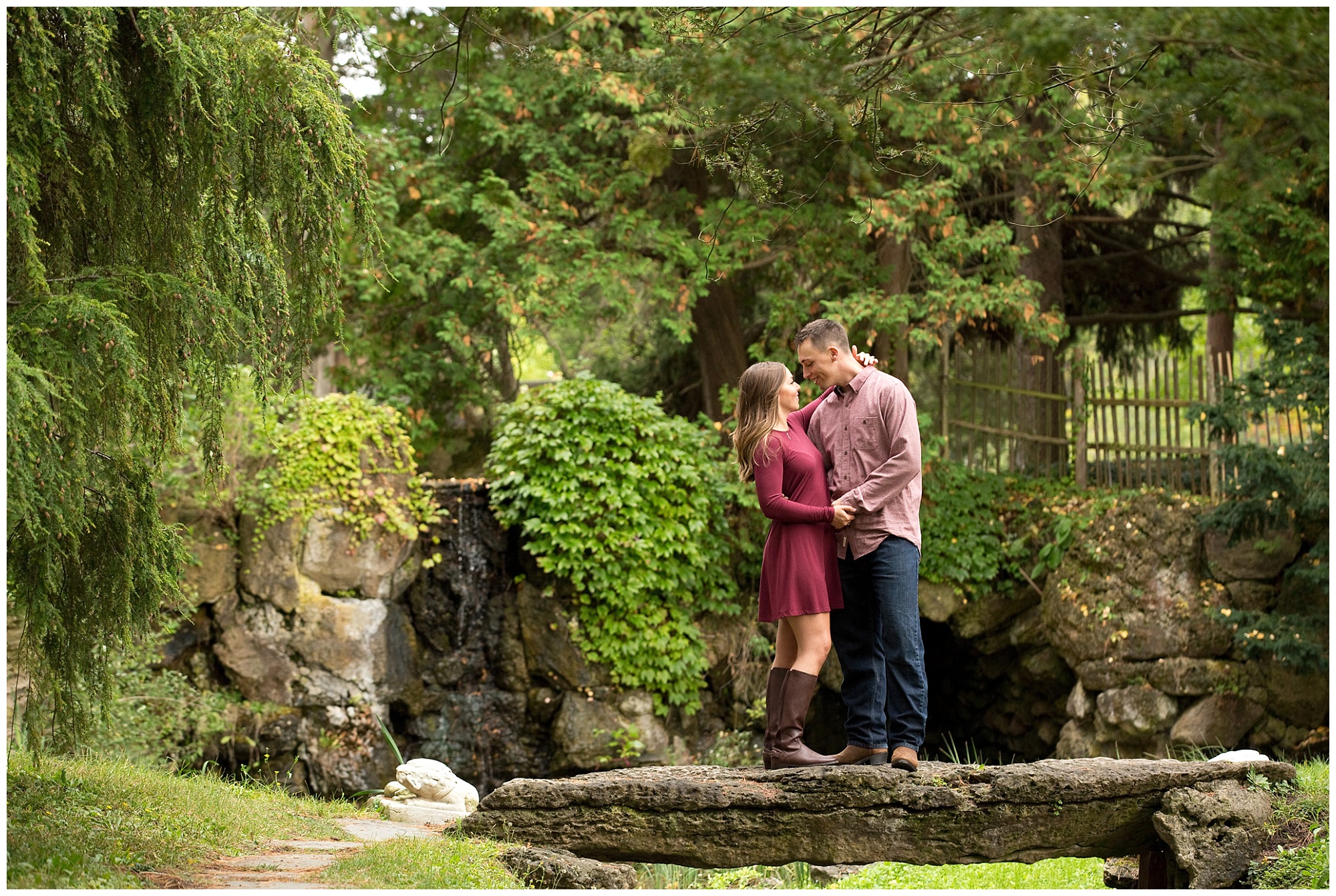 Photo of an engaged couple looking into eachother's eye while standing on a stone bridge.