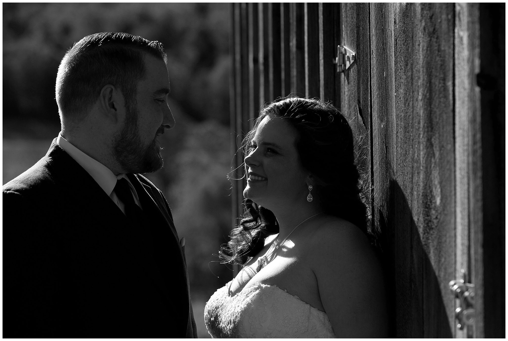 Photo of a bride and groom in black and white looking lovingly at each other.
