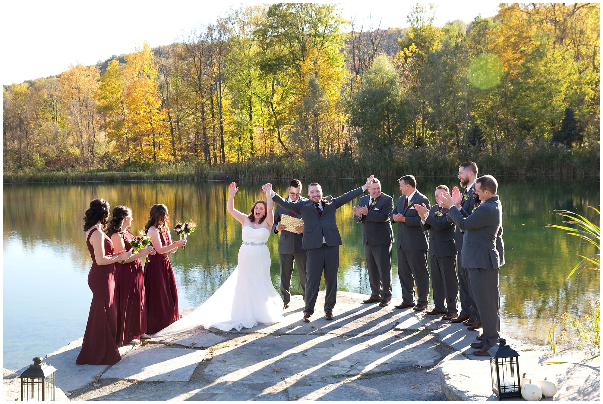 A bride and groom with thier hands raised in the air in celebration after being pronounced husband and wife.