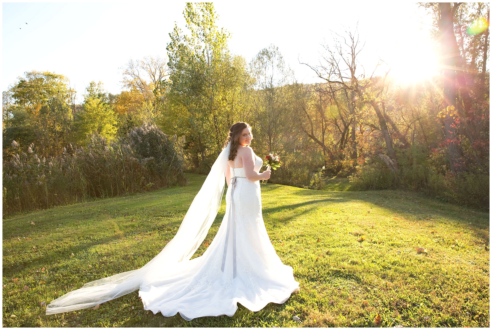 A bride portriat with her looking over her shoulder at the camera backlighted by the late autumn afternoon sunlight.