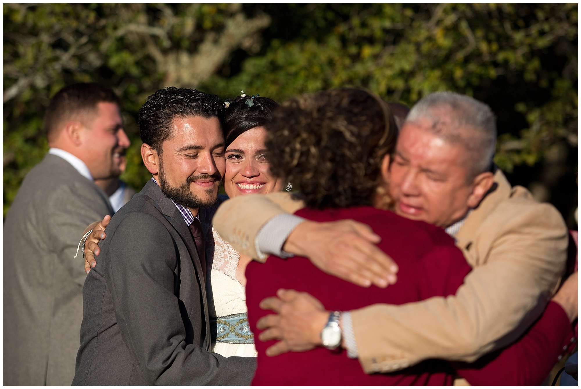 Photo of bride and her brother wathcing their parents in an embrace. 