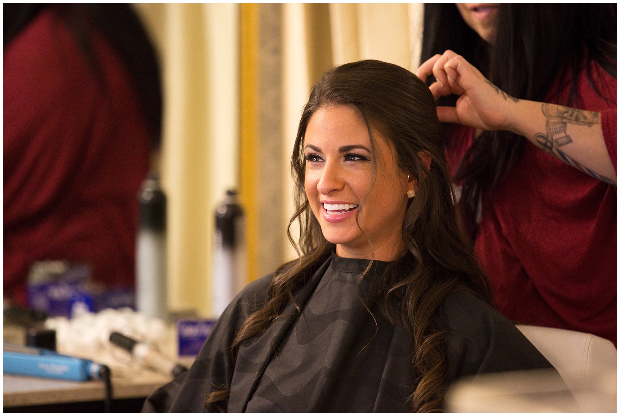 A smiling bride getting her hair done.