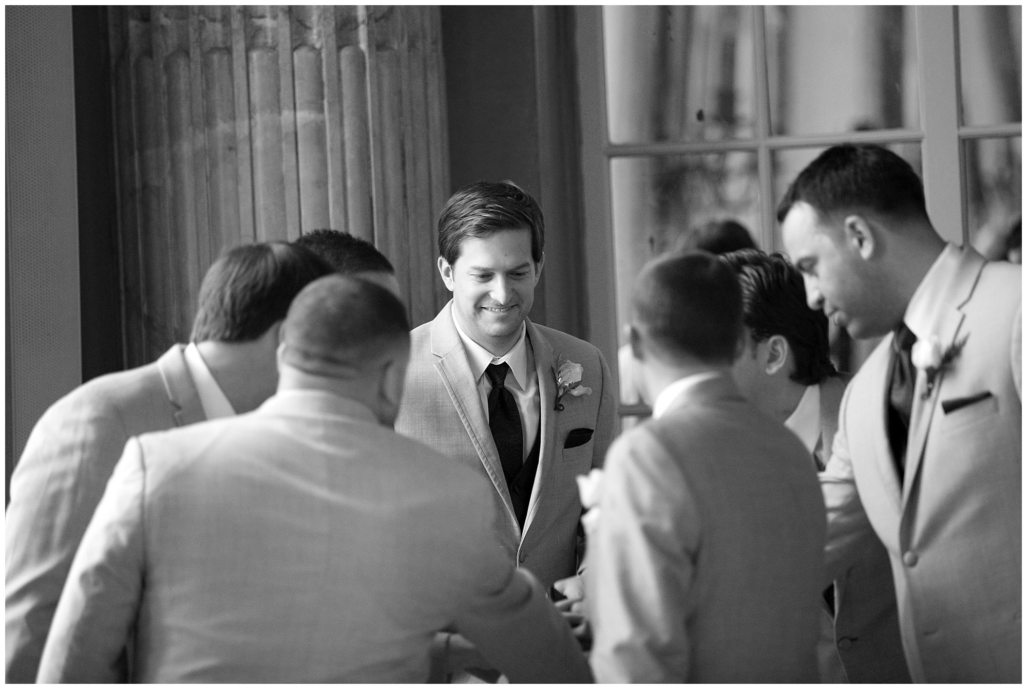 Photo of a groom and his groomsmen sharing a few words just prior to their procession to the wedding ceremony. 